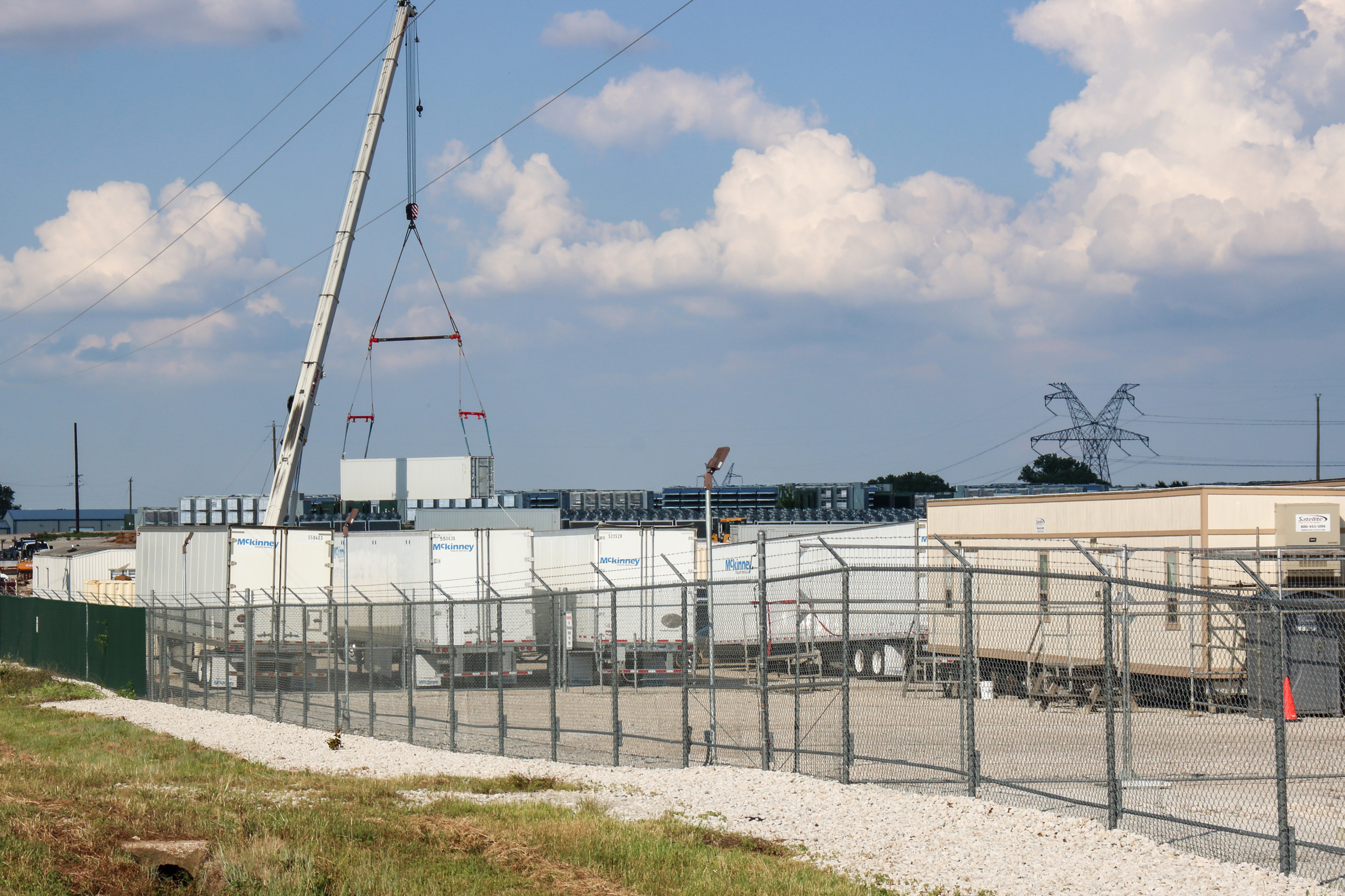 Trucks are parked alongside containers of computers owned by Marathon Digital at the Bitcoin mine in Granbury. Credit: Keaton Peters/Inside Climate News